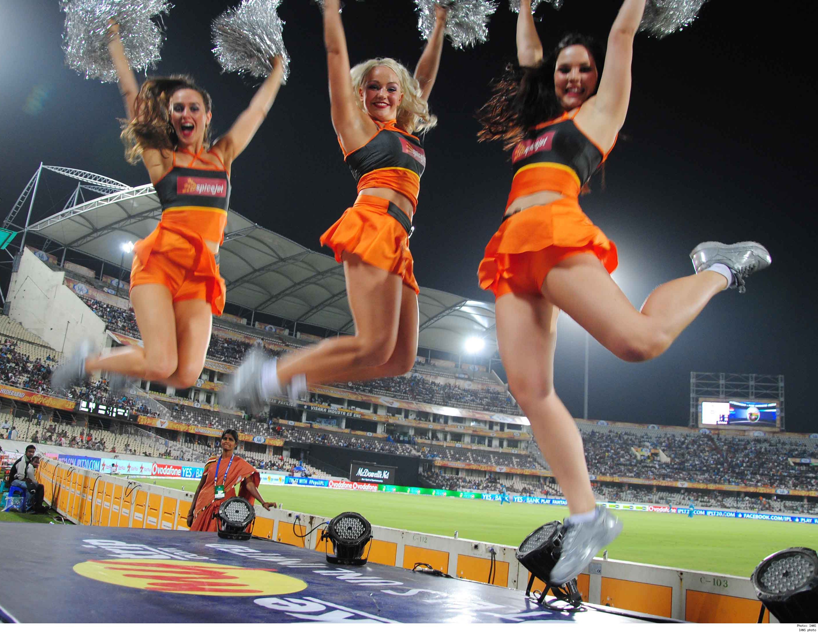 Cheerleaders leaping up high with their pompoms