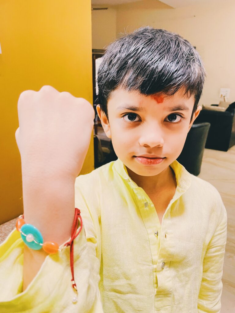 Showing off his repaired rakhi